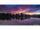 Stunning sunset over the water, reflecting the colorful sky and silhouetted trees in a serene and peaceful lakeside setting at 4599 B & C Dr, Catawba, NC 28609