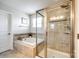 Bright bathroom featuring a glass shower, soaking tub, and neutral tile at 5070 Saint Clair St, Fort Mill, SC 29715
