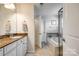 This bathroom features a soaking tub, glass shower door, dual sinks, and granite countertops for a spa feel at 5070 Saint Clair St, Fort Mill, SC 29715