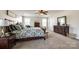Spacious primary bedroom with a ceiling fan, natural light, and dark wood furnishings for a warm feel at 5070 Saint Clair St, Fort Mill, SC 29715