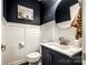 Stylish powder room featuring navy walls, white wainscoting, a modern vanity and round mirror at 5070 Saint Clair St, Fort Mill, SC 29715