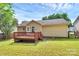 A backyard view of the home and wooden deck with a well-maintained lawn at 5114 Daffodil Ln, Concord, NC 28025