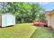 A well maintained backyard with green lawn, storage shed, and wooden deck at 5114 Daffodil Ln, Concord, NC 28025
