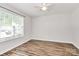 A bright bedroom featuring wood flooring, a ceiling fan, and a large window at 5114 Daffodil Ln, Concord, NC 28025