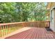 A spacious wooden deck overlooks a beautifully landscaped and wooded backyard at 5114 Daffodil Ln, Concord, NC 28025