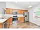 Kitchen featuring wood cabinets, stainless steel appliances, and hardwood flooring at 5114 Daffodil Ln, Concord, NC 28025