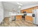 Kitchen showcasing wood cabinets, stainless steel appliances, and hardwood flooring at 5114 Daffodil Ln, Concord, NC 28025