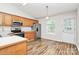 Well-lit kitchen with wood cabinets, stainless steel appliances, and view of the door and backyard at 5114 Daffodil Ln, Concord, NC 28025