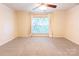 Bright, carpeted bedroom featuring a ceiling fan and a large window at 525 N Graham St, Charlotte, NC 28202