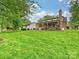 Wide view of the backyard with large green lawn, covered patio and bonus building at 5624 Warewhip Ln, Charlotte, NC 28210