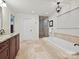 This bright bathroom features a soaking tub, glass shower, and granite countertops at 5624 Warewhip Ln, Charlotte, NC 28210