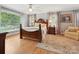This bedroom features a large window, wood flooring, ceiling fan, and stylish furnishings at 5624 Warewhip Ln, Charlotte, NC 28210