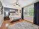 Modern bedroom with hardwood floors, a ceiling fan, neutral colors, and lots of natural light at 5624 Warewhip Ln, Charlotte, NC 28210