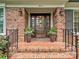 Close-up of a brick front porch with planters framing the wood front door at 5624 Warewhip Ln, Charlotte, NC 28210
