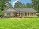 Charming brick home with a manicured front lawn, mature trees, and shutters at 5624 Warewhip Ln, Charlotte, NC 28210