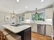 Bright kitchen featuring white cabinetry, stainless appliances, a cooktop island, pendant lighting, and a spacious breakfast area at 5624 Warewhip Ln, Charlotte, NC 28210