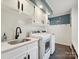 Well-appointed laundry room with modern washer and dryer, sink, and storage at 5624 Warewhip Ln, Charlotte, NC 28210