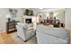 Living room featuring a white-washed brick fireplace, mounted TV, and views to a staircase and other living areas at 5624 Warewhip Ln, Charlotte, NC 28210