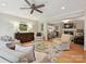 Bright living room boasts a ceiling fan, hardwood floors, neutral paint and seamless flow into other living spaces at 5624 Warewhip Ln, Charlotte, NC 28210