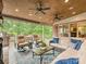 Relaxing outdoor living area with comfortable seating, ceiling fans and wooded view at 5624 Warewhip Ln, Charlotte, NC 28210