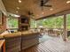Expansive outdoor living area with a stone fireplace, ceiling fans, and comfortable seating at 5624 Warewhip Ln, Charlotte, NC 28210
