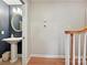 A well-lit powder room with a pedestal sink and a round mirror. Hardwood floors on entry at 5624 Warewhip Ln, Charlotte, NC 28210