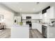 Modern kitchen features stainless steel appliances, white cabinets, granite countertops, and a central island for meal preparation at 5782 Knox Ln, Kannapolis, NC 28081