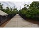 Paved walking bridge with black railings, surrounded by lush greenery and trees at 62 Fourth St, Cramerton, NC 28032