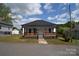 Charming home with a inviting front porch with a black roof, and landscaped front yard at 62 Fourth St, Cramerton, NC 28032