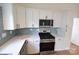 Contemporary kitchen with stainless appliances, white cabinets, and tiled backsplash at 62 Fourth St, Cramerton, NC 28032