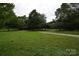 Lush green park with walking paths, mature trees, and a gazebo under a cloudy sky at 62 Fourth St, Cramerton, NC 28032
