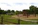 Playground area with playground equipment, picnic tables, and lush greenery under a cloudy sky at 62 Fourth St, Cramerton, NC 28032