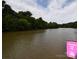 View of the calm river next to Riverside Park Pier, surrounded by lush green trees at 62 Fourth St, Cramerton, NC 28032