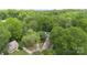 Aerial view of a house with a large treed lot, featuring a long driveway and verdant canopy at 6736 Raeburn Ln, Charlotte, NC 28227