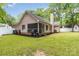 Wide view of the backyard and side of the house, lush green lawn and tree lined perimeter at 6736 Raeburn Ln, Charlotte, NC 28227