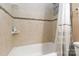 A bathtub with a shower, neutral tile, and functional fixtures are featured in this bathroom at 6736 Raeburn Ln, Charlotte, NC 28227