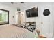 Functional bedroom with hardwood floors, a ceiling fan, mounted television, and white trim at 6736 Raeburn Ln, Charlotte, NC 28227