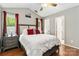 A comfortable bedroom with a high ceiling and a window with red curtains at 6736 Raeburn Ln, Charlotte, NC 28227
