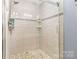 A glass enclosed tile shower is enhanced with a pebble tile floor and modern fixtures at 6736 Raeburn Ln, Charlotte, NC 28227