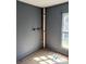 Corner of room featuring gray paneled walls, window and exposed pipes at 723 Pee Dee Ave, Albemarle, NC 28001