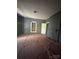 A room with uncovered floors, featuring a faux fireplace and a window at 723 Pee Dee Ave, Albemarle, NC 28001