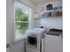 Bright laundry room with washer, dryer, window, and shelving for storage at 744 Chipmeadow Ln, York, SC 29745