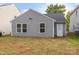 Back of house featuring two windows, door, siding, and a spacious lawn at 7616 Monarch Birch Ln, Charlotte, NC 28215