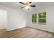 This bedroom boasts a ceiling fan, two windows bringing in natural light, and laminate flooring at 7616 Monarch Birch Ln, Charlotte, NC 28215