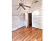 Upstairs bedroom featuring hardwood floors, storage, window and log-cabin style whitewashed walls at 7811 Babe Stillwell Farm Rd, Huntersville, NC 28078