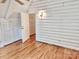 Upstairs bedroom featuring hardwood floors, storage and log-cabin style whitewashed walls at 7811 Babe Stillwell Farm Rd, Huntersville, NC 28078