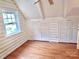 Upstairs bedroom featuring hardwood floors, storage, window and log-cabin style whitewashed walls at 7811 Babe Stillwell Farm Rd, Huntersville, NC 28078