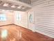 Bright living room with hardwood floors, chandelier, and log-cabin style whitewashed walls at 7811 Babe Stillwell Farm Rd, Huntersville, NC 28078
