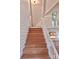 Wooden staircase leading to an upstairs area, with the kitchen visible in the background at 7811 Babe Stillwell Farm Rd, Huntersville, NC 28078