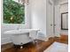 Bright bathroom featuring a clawfoot tub, chandelier, and a large window with private green views at 7906 Skye Lochs Dr, Waxhaw, NC 28173